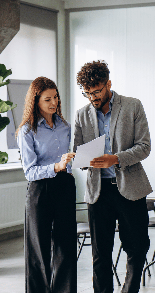 Two Business Professionals Looking at Paper in an Office