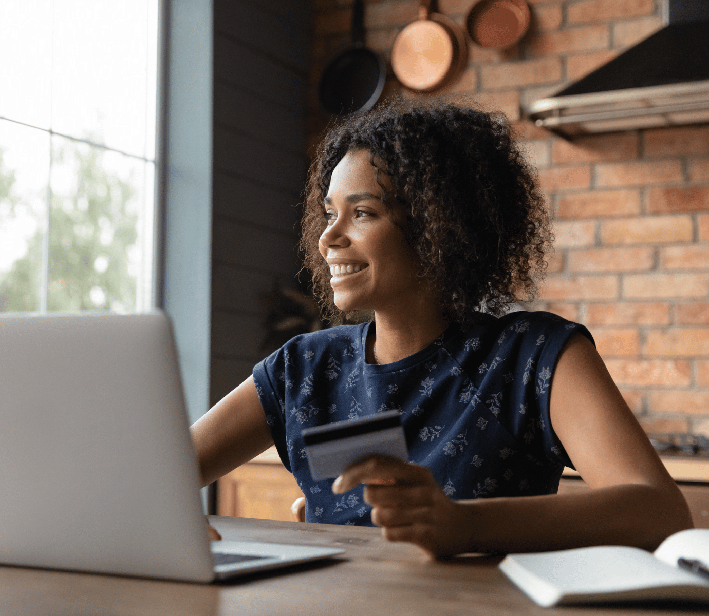 Woman Looking Out at Window Smiling While Shopping Online