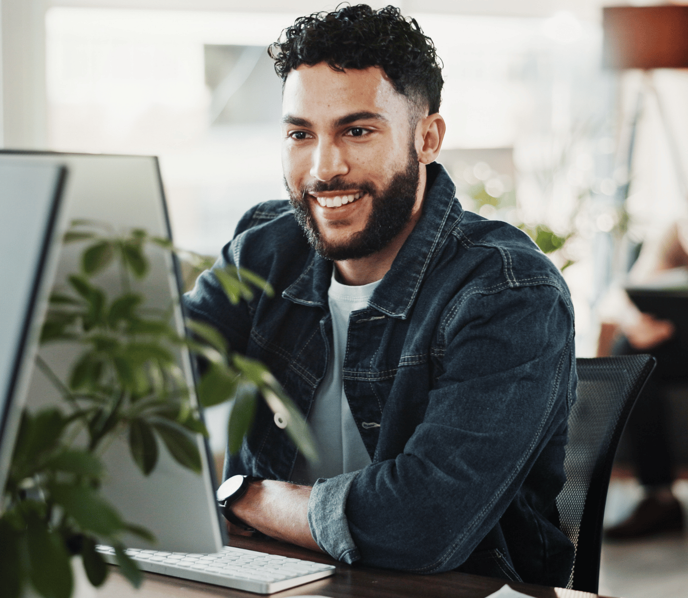 Man Smiling While Looking at Computer In Office