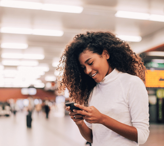 Young Adult Consumer on Phone in Train Station